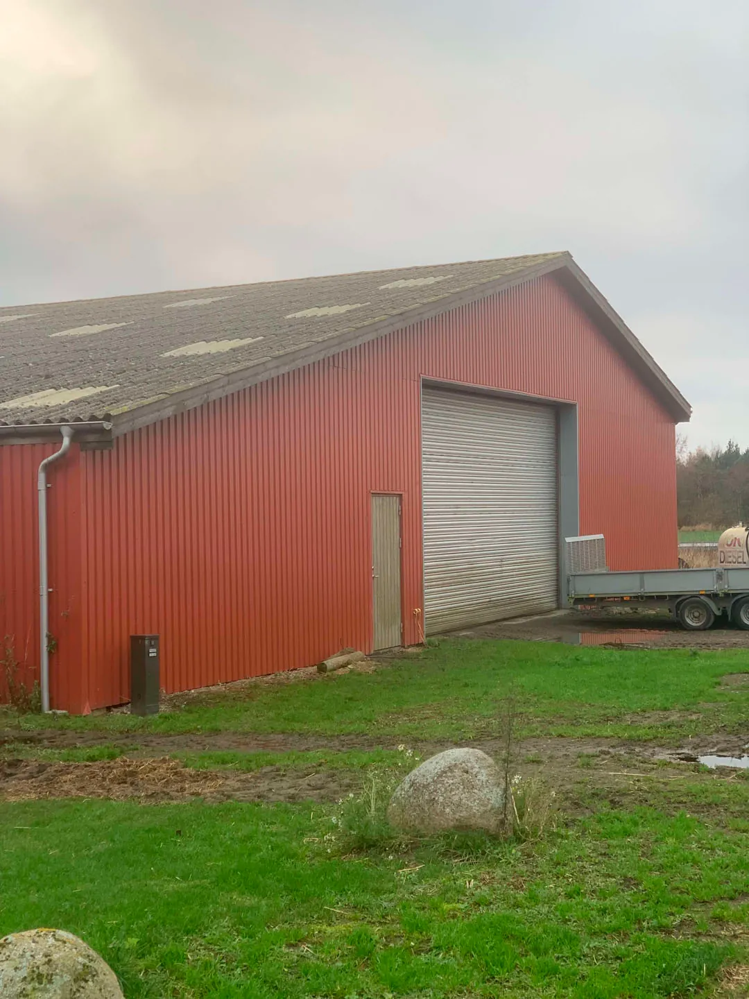 Nyt mørkt træskur med sort skifertag opbygget i have